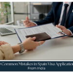 Indian traveler reviewing Spain visa application documents with passport, embassy checklist, and travel papers to avoid common Spain visa mistakes from India