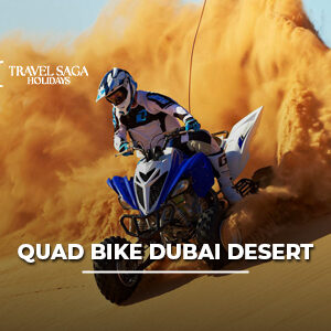 Quad bike rider speeding across Dubai desert dunes during an adventure safari experience.
