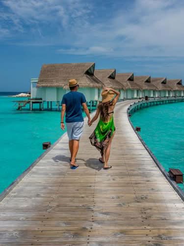 Maldives tour packages from India featuring luxury water villas, white sandy beaches, crystal-clear waters, and breathtaking ocean views.